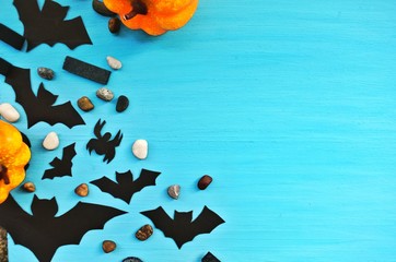 Top view Happy halloween holiday concept. Halloween decorations, pumpkins, bats,spider on blue background. Halloween party greeting card mockup with copy space.