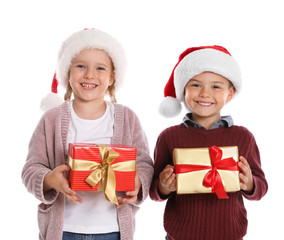 Happy little children in Santa hats with gift boxes on white background. Christmas celebration