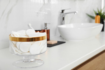 Fototapeta na wymiar Jar with cotton pads on bathroom countertop
