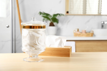 Jar with cotton pads on table in bathroom
