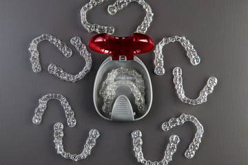 Top view of invisalign braces or invisible retainers on grey background, new orthodontic equipment