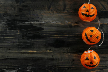 Orange pumpkin shaped lamps, creepy and funny Jack o Lantern decor lights on dark background. All...