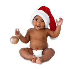 Cute African-American baby wearing Santa hat with Christmas decoration on white background