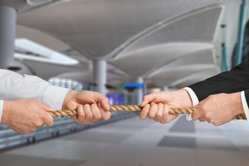 Business men hands holding rope on grey background