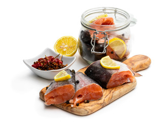 Salted rainbow trout slices with lemon slices on wooden board isolated on white