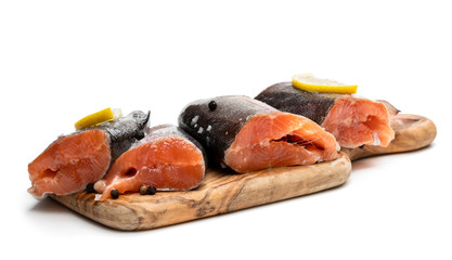 Salted rainbow trout slices with lemon slices on wooden board isolated on white