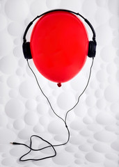 Red balloon with headphones flying on the air