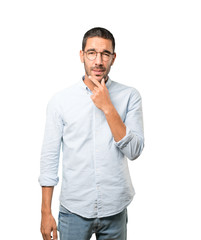 Concentrated young man making a gesture of distrust