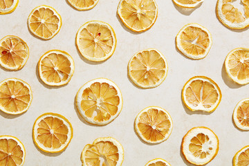 Sun dried lemon slices under hard sunlight with white stone background