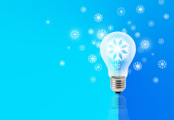 Light bulb with glowing snowflake inside on light blue grandiant background, Light up idea for christmas concept