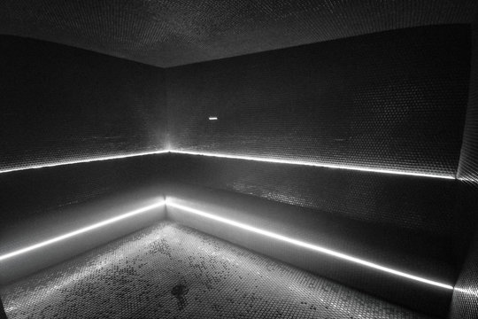 Steam room sauna spa at luxury hotel or modern condo amenities. Interior of  new clean black room with LED lights ligthing in the dark. Mobile picture  taken with phone. Stock Photo |
