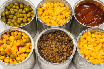 Canned food on white background. Green pea, beans, corn, lentils.