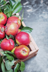 Red apple with leaf in wooden box on the old table