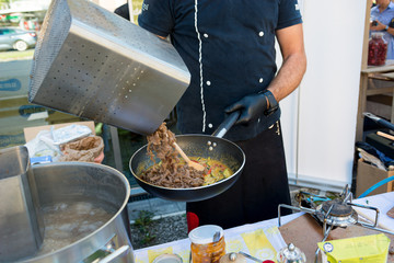 Chef preparing delicious organic pasta dish outdoor. Eating