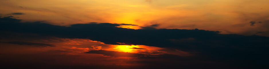 View to the sunset sky. Black and orange clouds.   