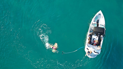 Aerial photo of woman practising waterski in Mediterranean bay with emerald sea at sunset © aerial-drone