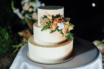 wedding cake three floors with fruit outside in the evening