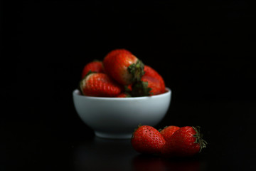a bowl of strawberry isolated on black background