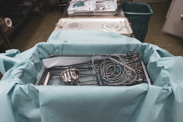 In a sterilization department in a hospital, cleaned instruments are wrapped in a blue cloth before...