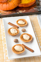 Sugary butter tart treats. Mini sugar pies (or butter tarts) with a crisp pastry crust, a sweet filling and pumpkin spice whipped cream on top. A tasty dessert for fall holidays like halloween!