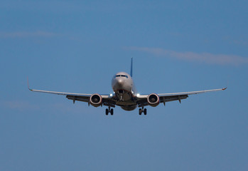 Fototapeta na wymiar Airplane flies against a background of blue sky