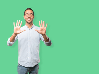 Young man making a number ten gesture