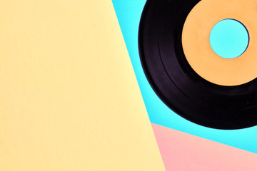 Vinyl record on pastel blue, yellow and pink background