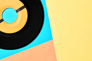 Vinyl record on pastel blue, yellow and pink background