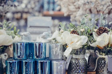 Silver, white, light blue Christmas New Year decorations on the store's display counter. Festive bouquets with flowers, cones and beads. Trends of Winter Holiday Decor. Selective focus, copy space.
