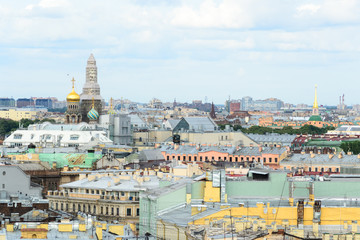 Cityscape view of Saint Petersburg, Russia. In the middle of the city roofs emerge the Church of the Savior of the Spilled Blood, under renovation at this time