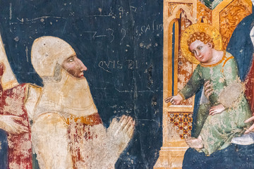 Religious medieval fresco showing baby Jesus receiving a crusader