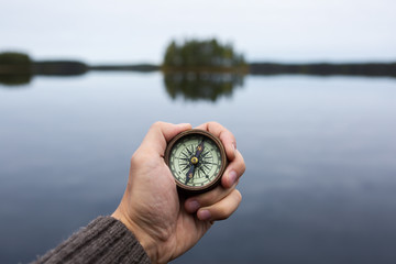 Traveler with compass seeking a right way in the forest during Hike.  Navigation concept in explore travel. © raland