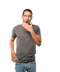 Bored young man yawning gesture