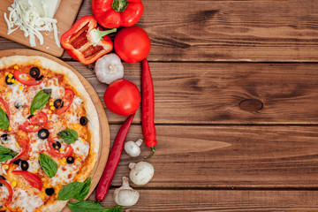 Pizza Margherita or Margarita with Mozzarella cheese, tomato, olive. Italian pizza on wooden background