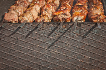 Slice pieces of meat on the grill. barbecue at the festival. Cheese and roasted veal on skewers.