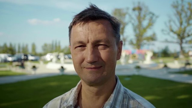 Shot of handsome man look at camera smile feel happy summer elderly face outdoor footage travel rest silhouette sky sun sunset portrait close up slow motion