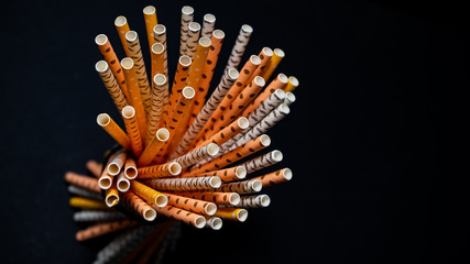 Stack of paper straws isolated on black background