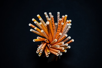 Stack of paper straws isolated on black background