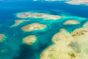 Coral reefs and lagoons, top view. Atolls and turquoise sea water. Sea surface.