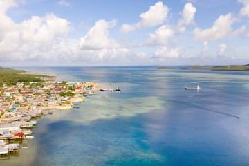 Sea port in the city of Dapa, Philippines. Fishing village and ships, view from above. Seascape in sunny weather.