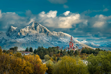 Red Buksnes church in front of snowy mountains at Lofoten Islands