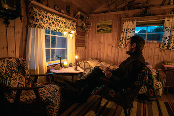 Young man in a Cozy old cabin on Senja Island
