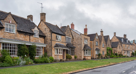Naklejka premium BROADWAY, ENGLAND - MAY, 27 2018: Pretty Cottages with climbing plants in the village of Broadway, in the English county of Worcestershire, Cotswolds, UK 