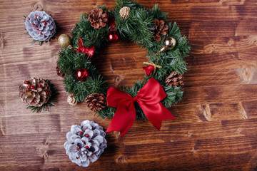 Christmas wreath with festive ornaments and decoration on a wooden background
