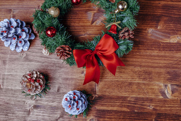 Christmas wreath with festive ornaments and decoration on a wooden background