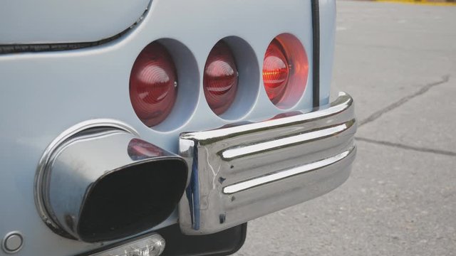 flashing taillights of a vintage light blue retro car