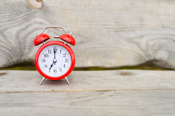 Vintage red clock and alarm clock on wooden background