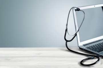 Laptop diagnosis with  stethoscope  on background