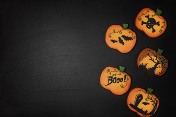 Halloween cookies in the shape of a pumpkin on a black background, copy space
