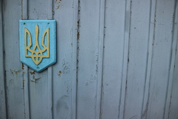 Ukraine sign on gates. Wall with UA emblem.